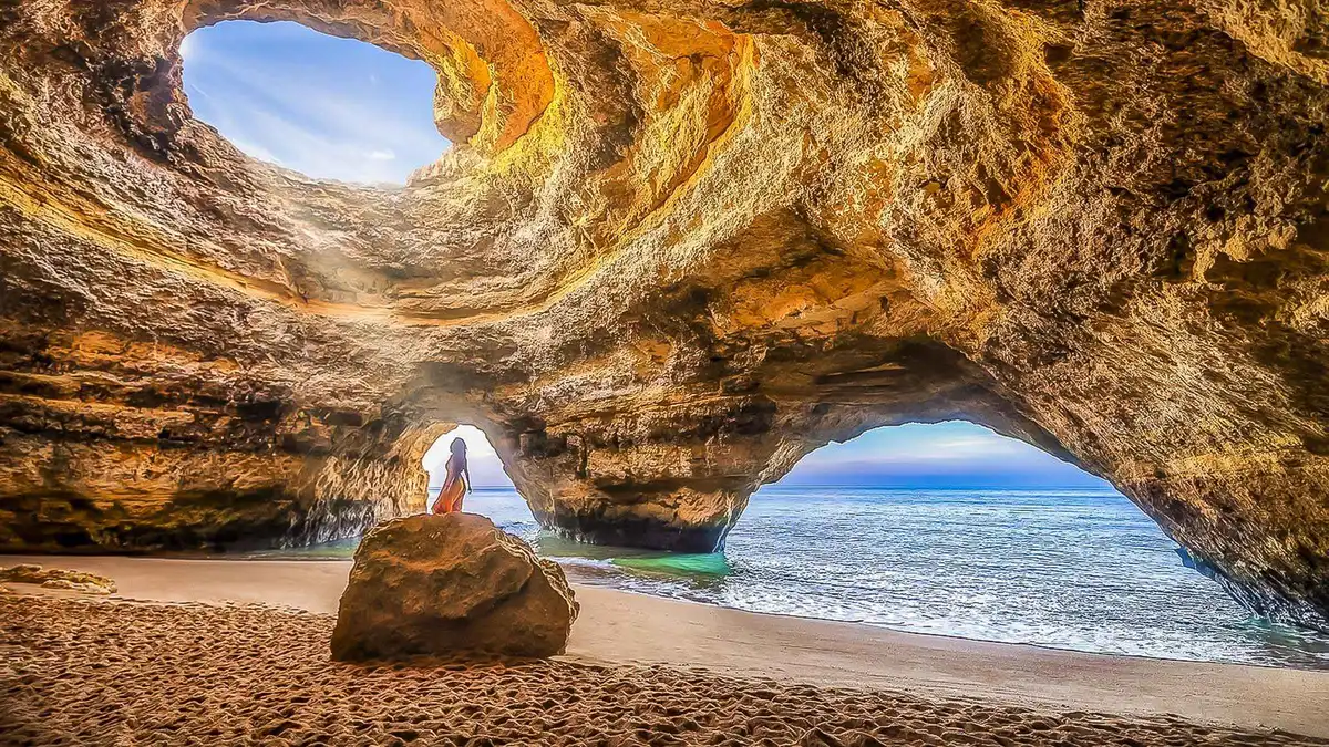 RIB speedboat passing the domed skylight opening of the Benagil sea cave on the Algarve coast near Portimão, Portugal